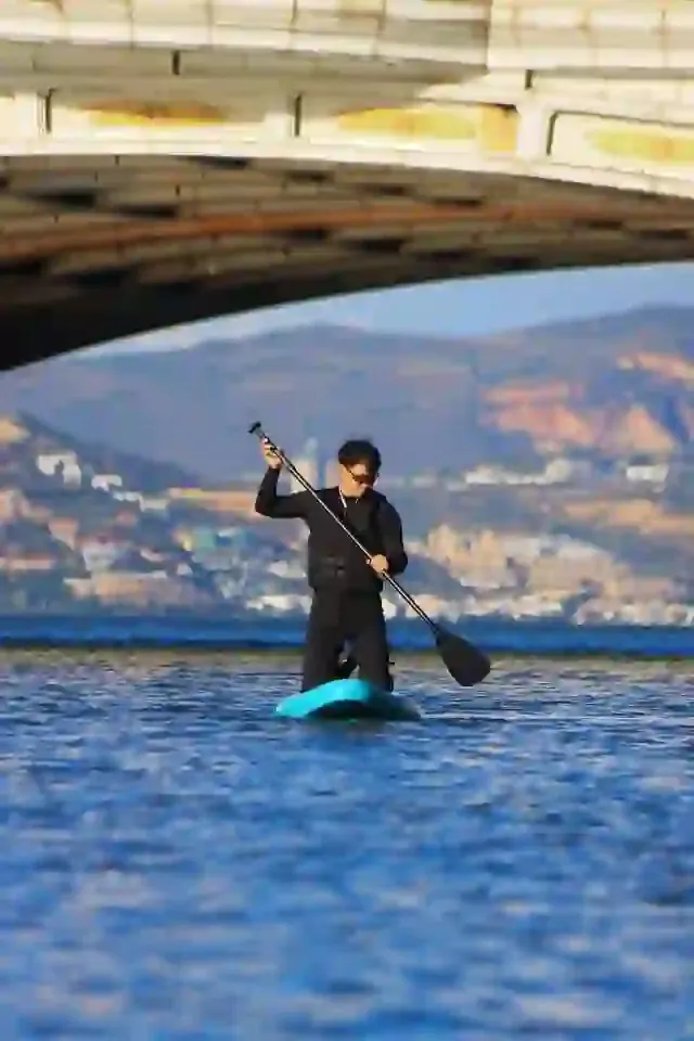 A paddleboarder on the calm water of Erhai Lake
