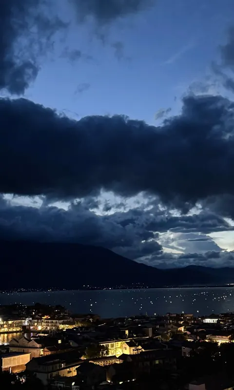 Shuanglang's lights beneath a dramatic evening sky