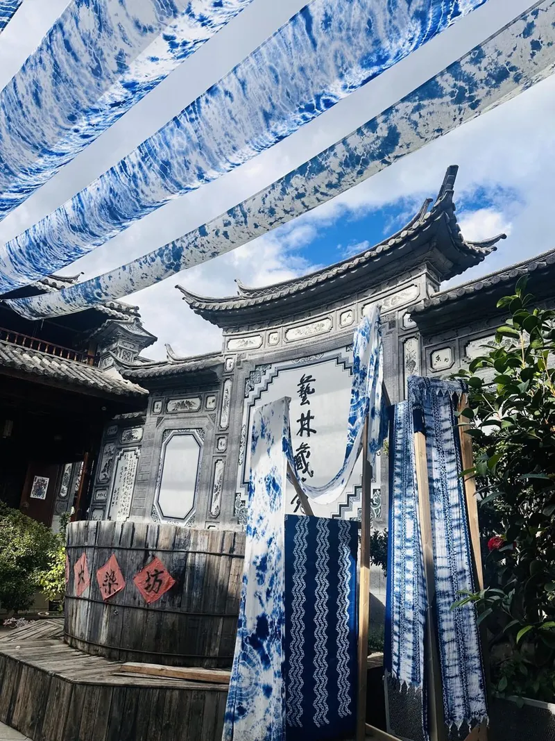 Indigo tie-dye cloth hanging over a Bai courtyard in Zhoucheng